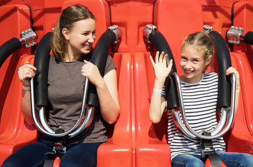 Mom and daughter are sitting on the attraction in the park. © M-Production
