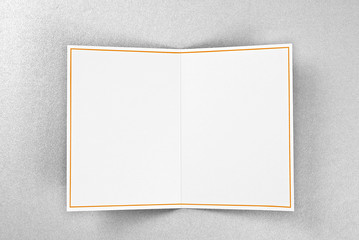 Blank greeting card decorated with gold frame over silver background