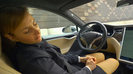 CLOSE UP: Caucasian businesswoman sleeping as autonomous car drives her home.