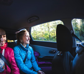 Two women in the back seat of a car.