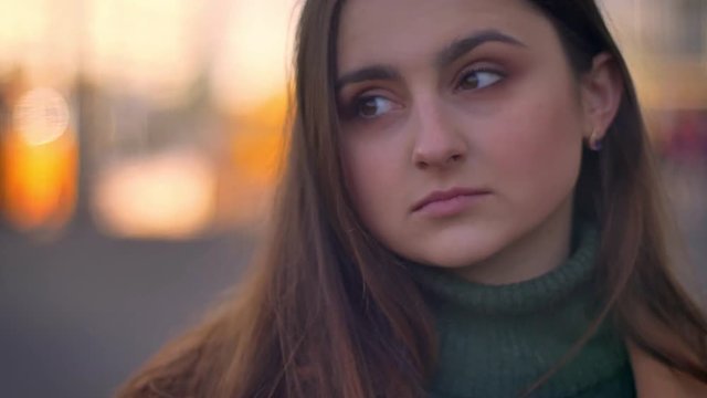 Confident strong caucasian female looking calmly at camera while standing isolated on urban background, city illustration, concentrated casual person