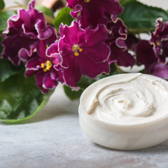 Cosmetic cream and red flowers.