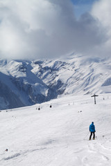 Fototapeta na wymiar Skier descend on snowy ski slope