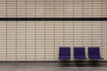Purple chairs attached to tiled wall