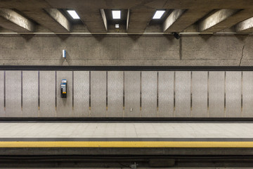 A lonely phone attached to tiled wall with ceiling beams