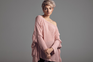 Fashion portrait of female model with blond short hair wear sweater
