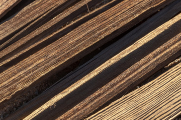 Diagonal weathered boards in dramatic shadows