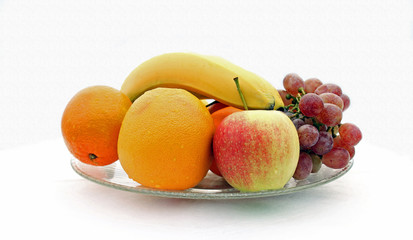 Äpfel, Orangen, Bananen, Weintrauben in einer Glasschale
