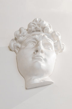 gypsum head of a man on the wall under the light