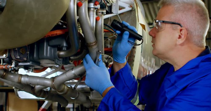 Engineer examining an aircraft engine in hangar 4k