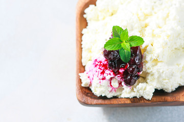 Homemade cottage cheese in a wooden bowl, diet concept.