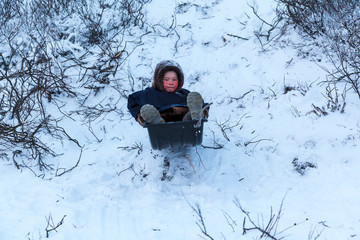 A resident of the tundra, indigenous residents of the Far North, tundra, open area, children ride on sledges, children  in national clothes,boy in the a Nenets-Malitsa clothing