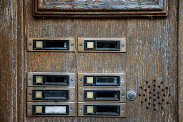 old rotten doorbells on a front door of an abandoned house