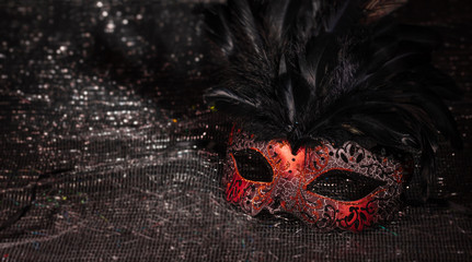 Red carnival mask on black shiny background