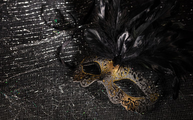 Gold carnival mask on black shiny background