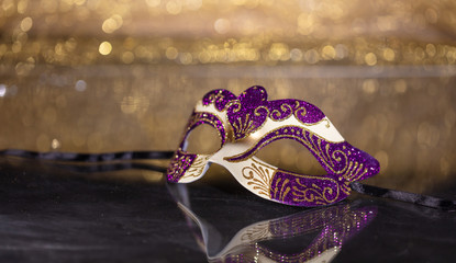 Carnival mask on golden bokeh background, copy space
