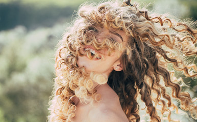 Blonde spring girl with curly beautiful hair smiling. Beauty hair Salon. Fashion haircut. Beauty...
