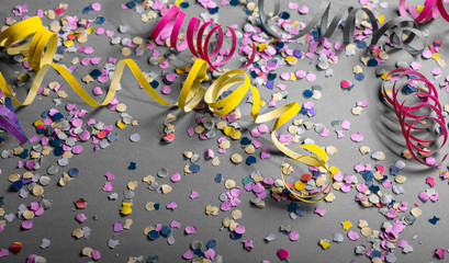 Carnival or birthday party, confetti and serpentines on grey background