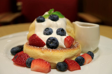 Closed Up a Plate of Fresh Mix Berries Souffle Pancake with Mascarpone Cream and Syrup 