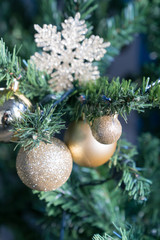 detail view of christmas tree with golden ornaments and bright golden star