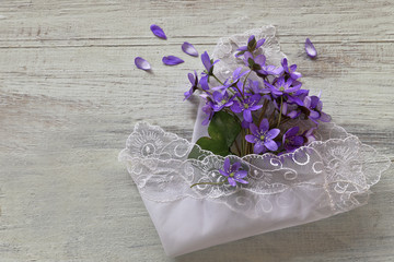 Hepatica flowers with lace napkin  on wooden background 
