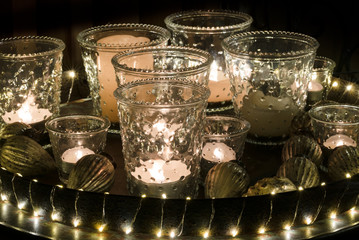 detail view of a decorative and festive Christmas holiday arrangement with glasses and candles and assorted decorative articles at night