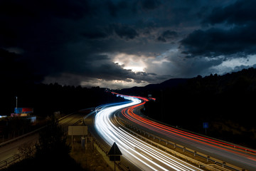 Highway With Traffic Light Trails and Storm on the Horizon in Barcelona Province (Spain)