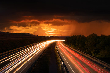 Fototapeta na wymiar Highway With Traffic Light Trails and Sunset and Storm in Barcelona Province (Spain)