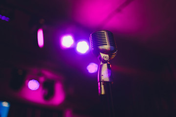 Retro microphone against blur colorful light restaurant background.