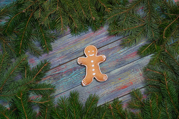 A gingerbread man with Christmas decorations and lots of fir branches.