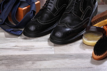 Brogue with brushes and wax on the wooden textures . Background.Shoes care