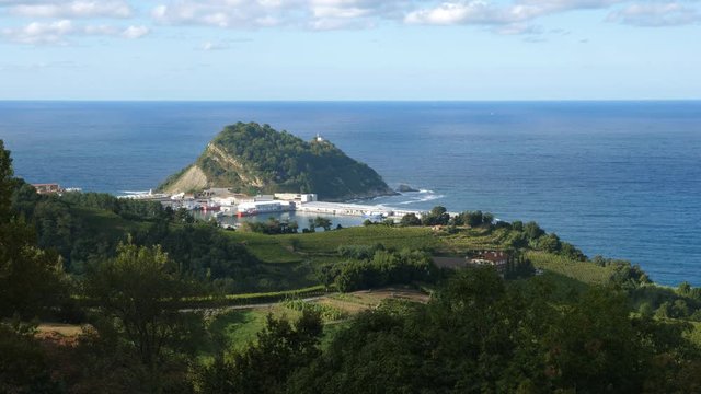 Harbour of Getaria with vineyards in foreground. Getaria, Spain with Isla de San Anton and Bay of Biscay in the distance.