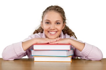 Friendly Young Girl Sitting Behind a Desk with a Books -