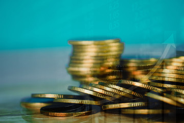 Double exposure of coin stack with stock market screen chart board and candle stick for financial business and investor analysis concept.
