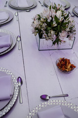 table decorated with round plates, a natural flower arrangement on a white wooden table, background for food presentations