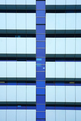 Glass blue square Windows of facade modern city business building skyscraper. Modern apartment buildings in new neighborhood. Windows of a building, texture.