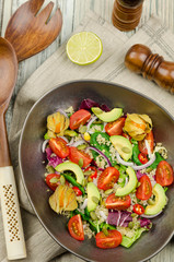 Fresh healthy summer salad with quinoa, avocado and cherry tomatoes. Fresh healthy quinoa salad on wooden background close up. Food and health. Superfood. 