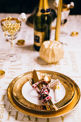 New year table setting with exclusive and luxury golden cutlery, over a tabletop with celebrations world 