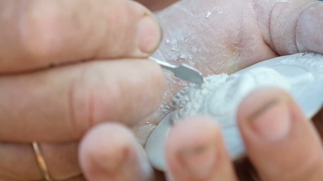 Craftsman`s hand cutting a white stone to make a souvenir in Askania-Nova 
