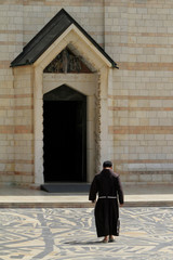 Jerusalem, Israel - July 12, 2016: A monk in traditional clothing entering a beautiful marble church in Israel