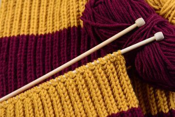 knitting scarf and needles n table wood