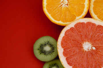 citrus fruits on red background close up