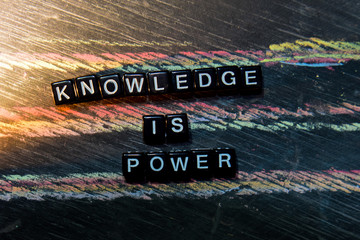 Knowledge is Power on wooden blocks. Cross processed image with blackboard background. Inspiration, education and motivation concepts