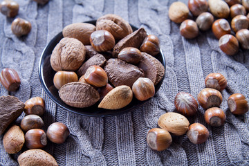 Mixed nuts in shells on the natural background: hazelnut, walnut, Brazil nut and almond.