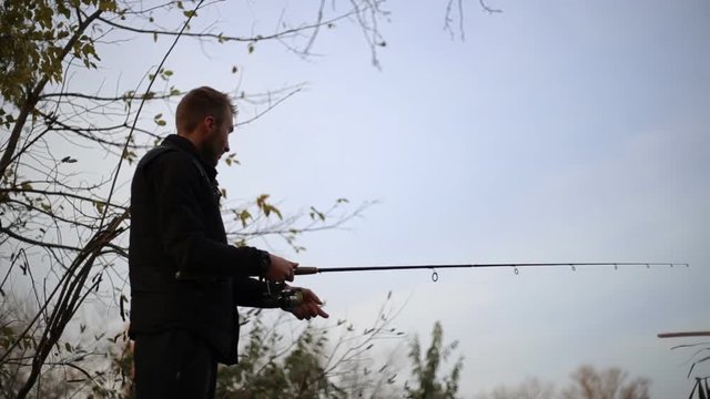 Fishing. Sport fishing. A young man throws spinning. Video from a motorized slider.