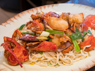 Close up shot of a Chinese style fried lobster and noodles
