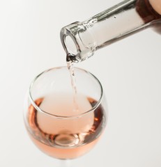 Transparent glass of wine. Pink wine. Festive mood. Alcohol for a group of friends. Delicious drink. Light background. Noble drink. Lavender and rose wine. Wine from lavender