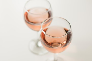 Transparent glass of wine. Pink wine. Festive mood. Alcohol for a group of friends. Delicious drink. Light background. Noble drink. Lavender and rose wine. Wine from lavender