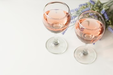 Transparent glass of wine. Pink wine. Festive mood. Alcohol for a group of friends. Delicious drink. Light background. Noble drink. Lavender and rose wine. Wine from lavender