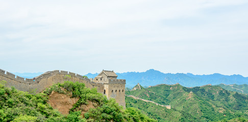 Fototapeta na wymiar A View of a Guard House on the Top of The Great Wall of China as it Bends its way through the Jinshanling Mountains